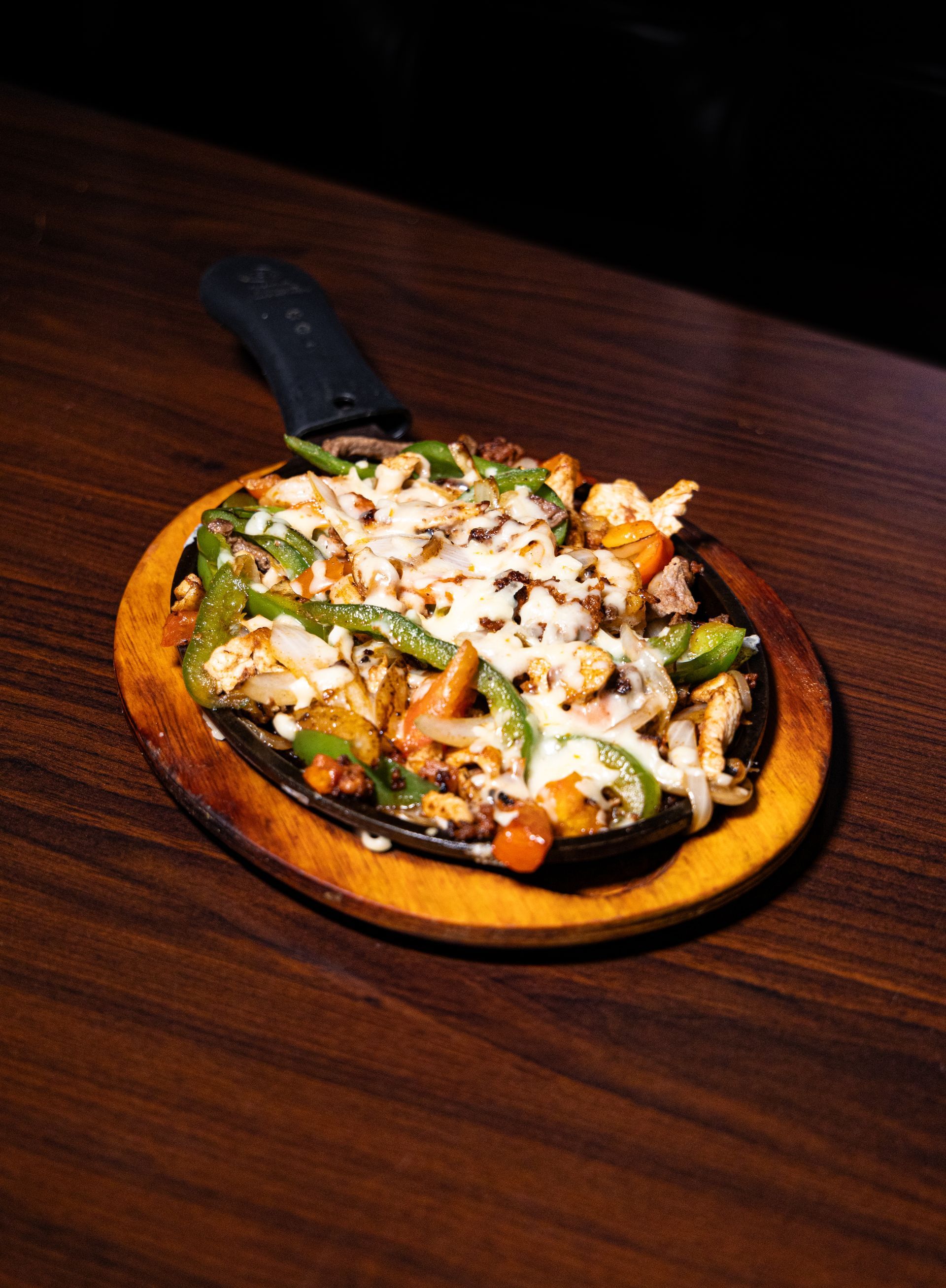Plate of Mexican food with rice, lettuce, tomatoes, and white sauce.