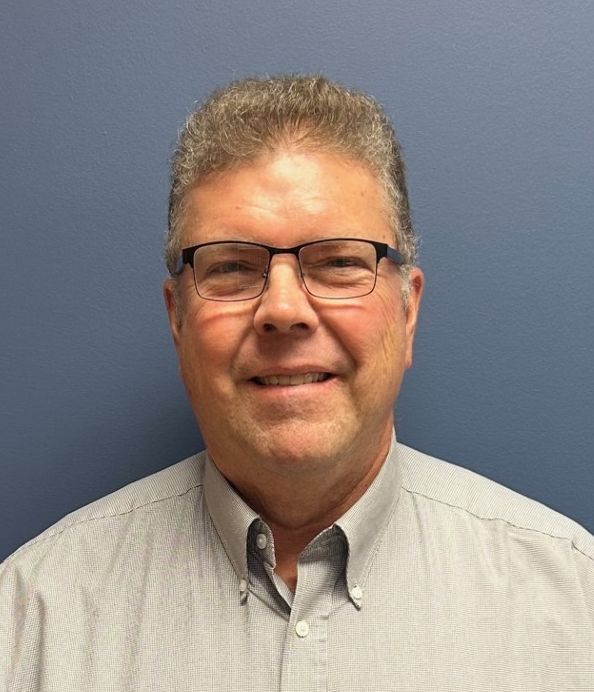 A man wearing glasses and a button down shirt is smiling for the camera. — Ames, IA — Howell Investment Finance