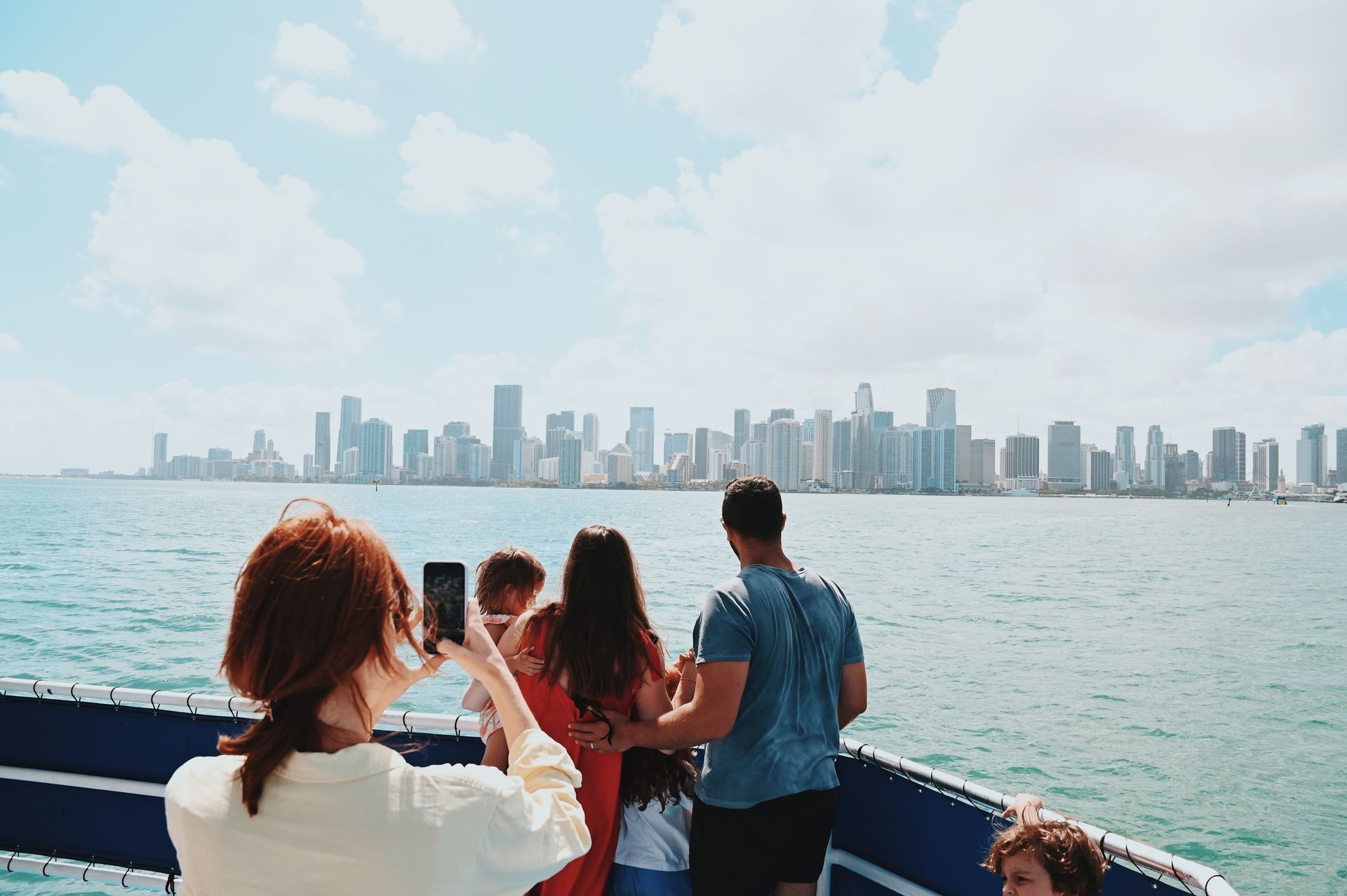 What to do in Miami for a day: guest taking a photo on a Miami boat tour with the Downtown Miami skyline in the background