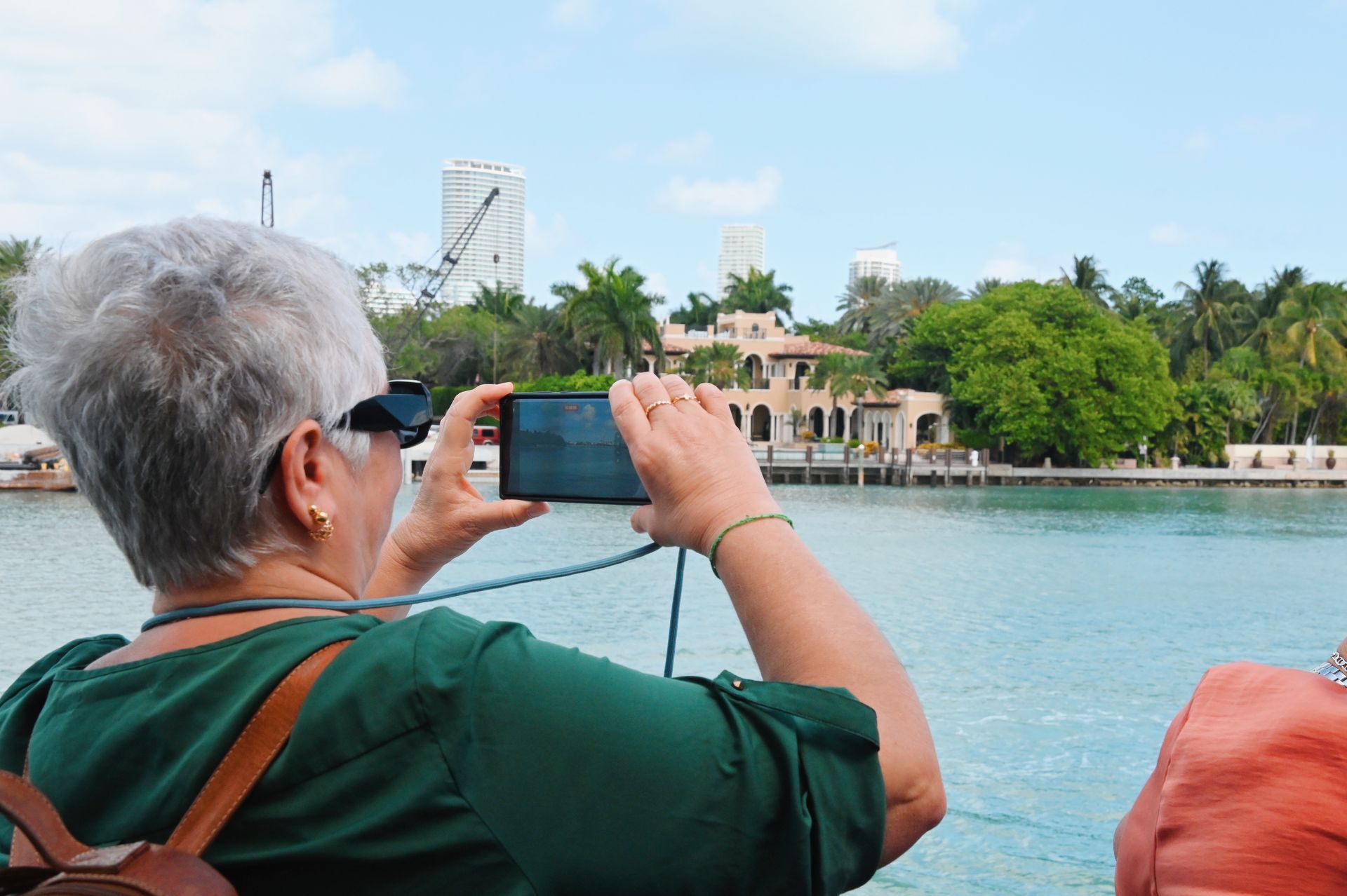 Passenger on the Miami Boat tour taking photos of the Mansions in Star Island