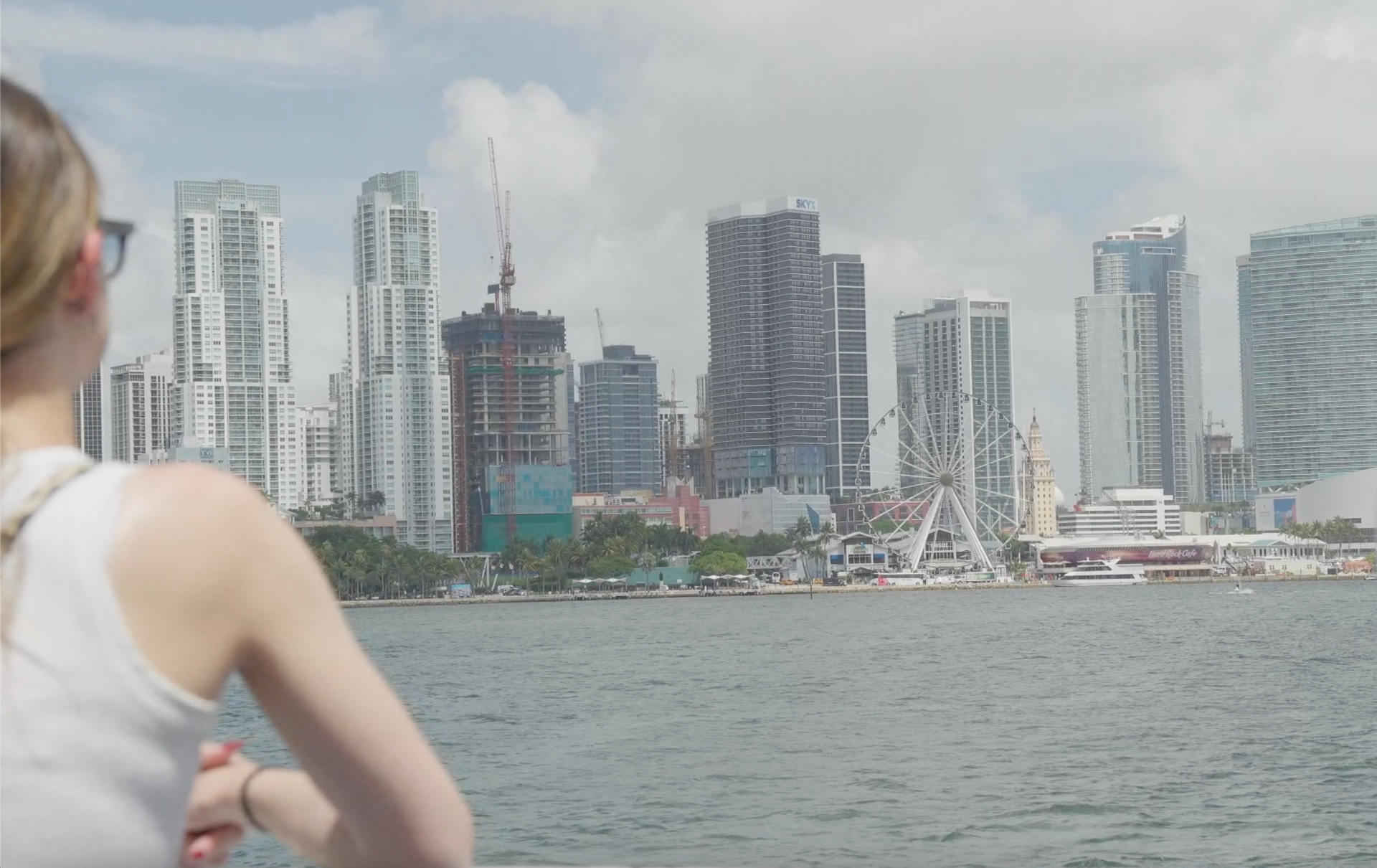 Passenger admiring the Miami skyline from the top deck of a Miami sightseeing boat tour