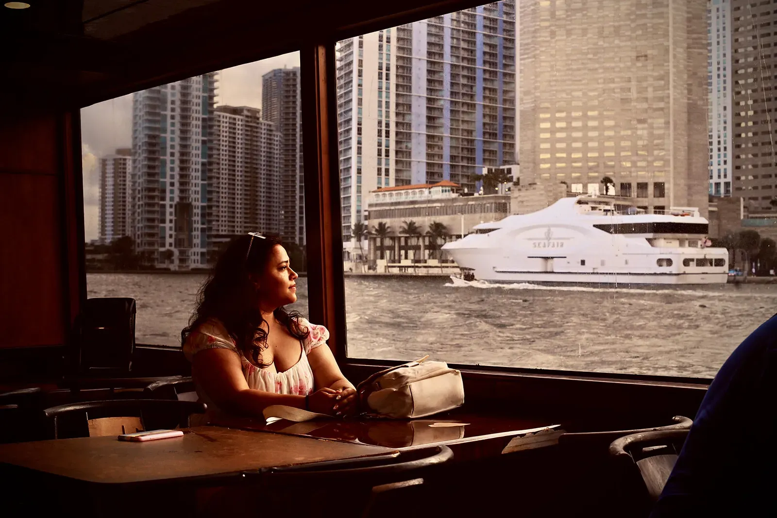 Guest relaxing inside a Bayside Miami Sunset Cruise with waterfront skyline views