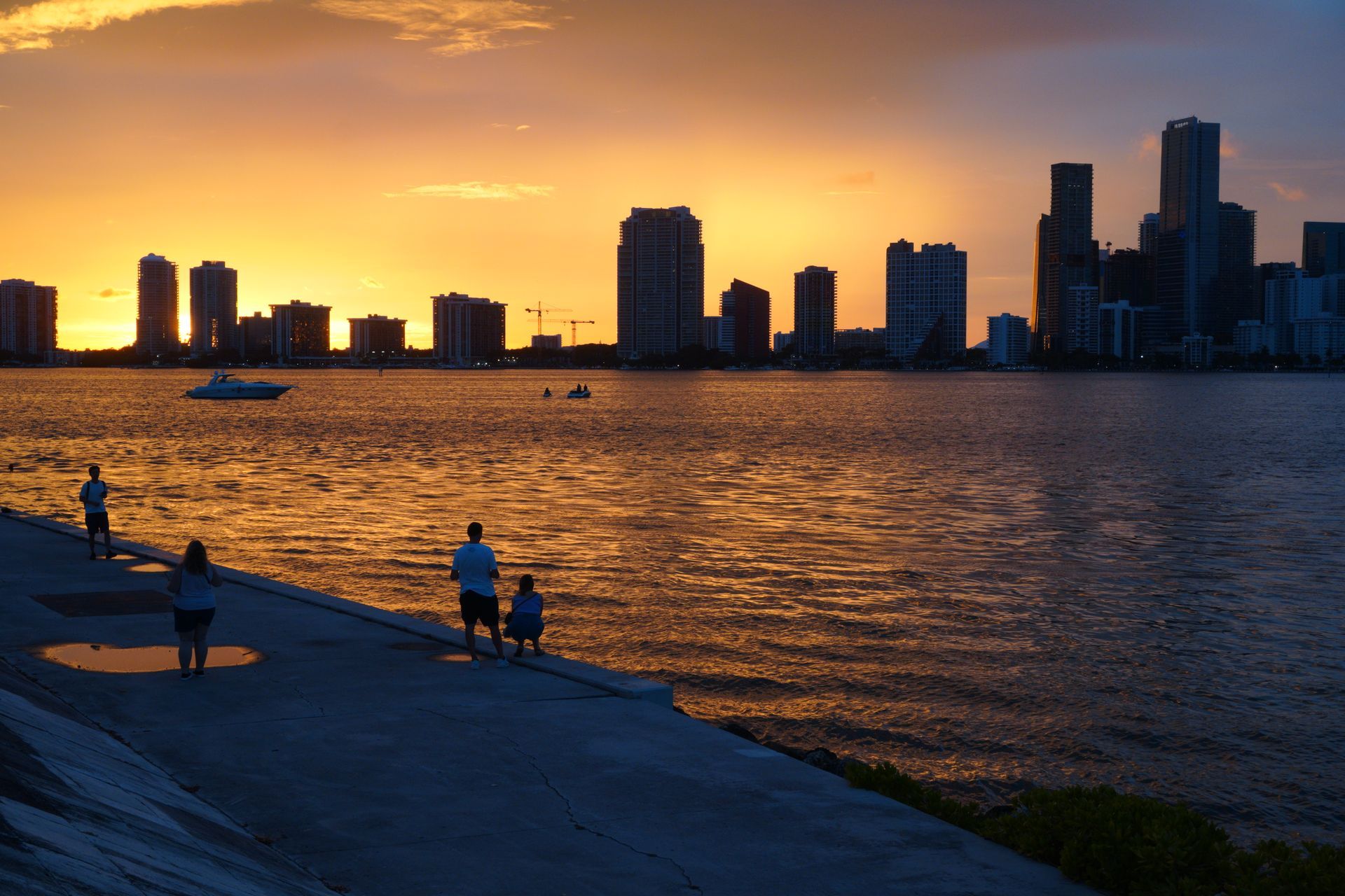 People watching the Miami skyline at sunset from the Biscayne Bay shoreline