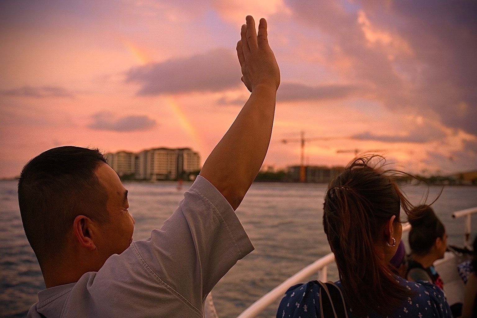 Guests waving on sunset cruise deck