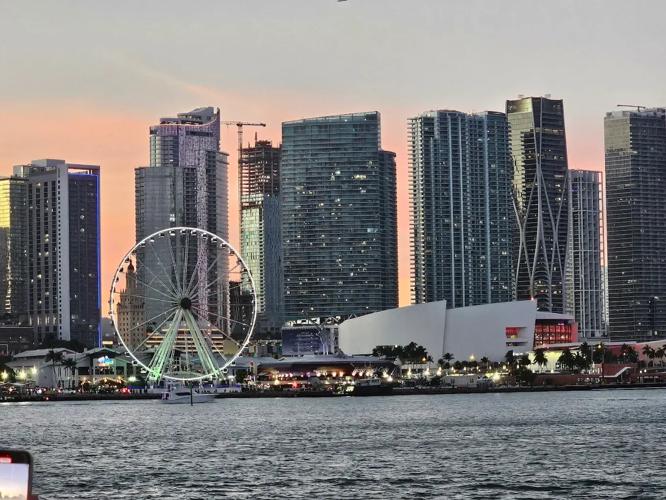 Sunset view of the Downtown Miami waterfront skyline featuring Skyviews Miami, Kaseya Center, modern skyscrapers, and Biscayne Bay.