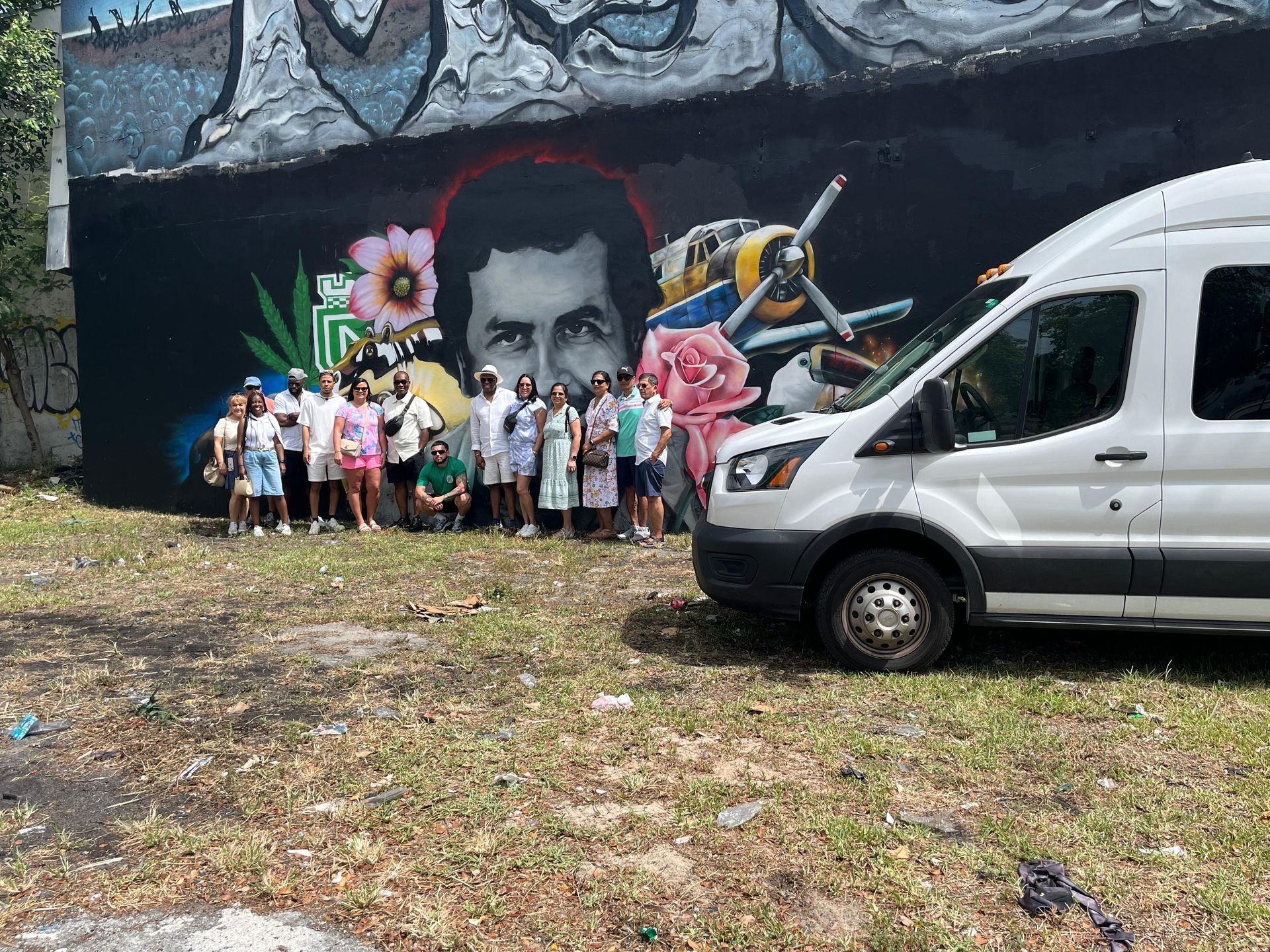 Guided Miami city tour group posing at Wynwood graffiti mural stop with private sightseeing van