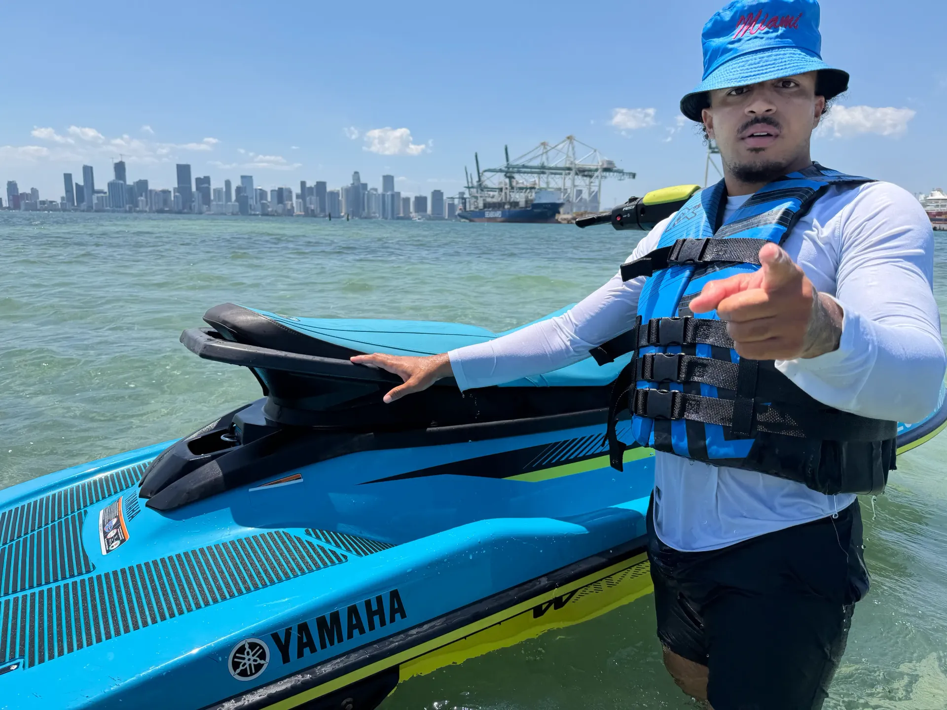Miami jet ski tour guide standing beside a jet ski with skyline views in the background