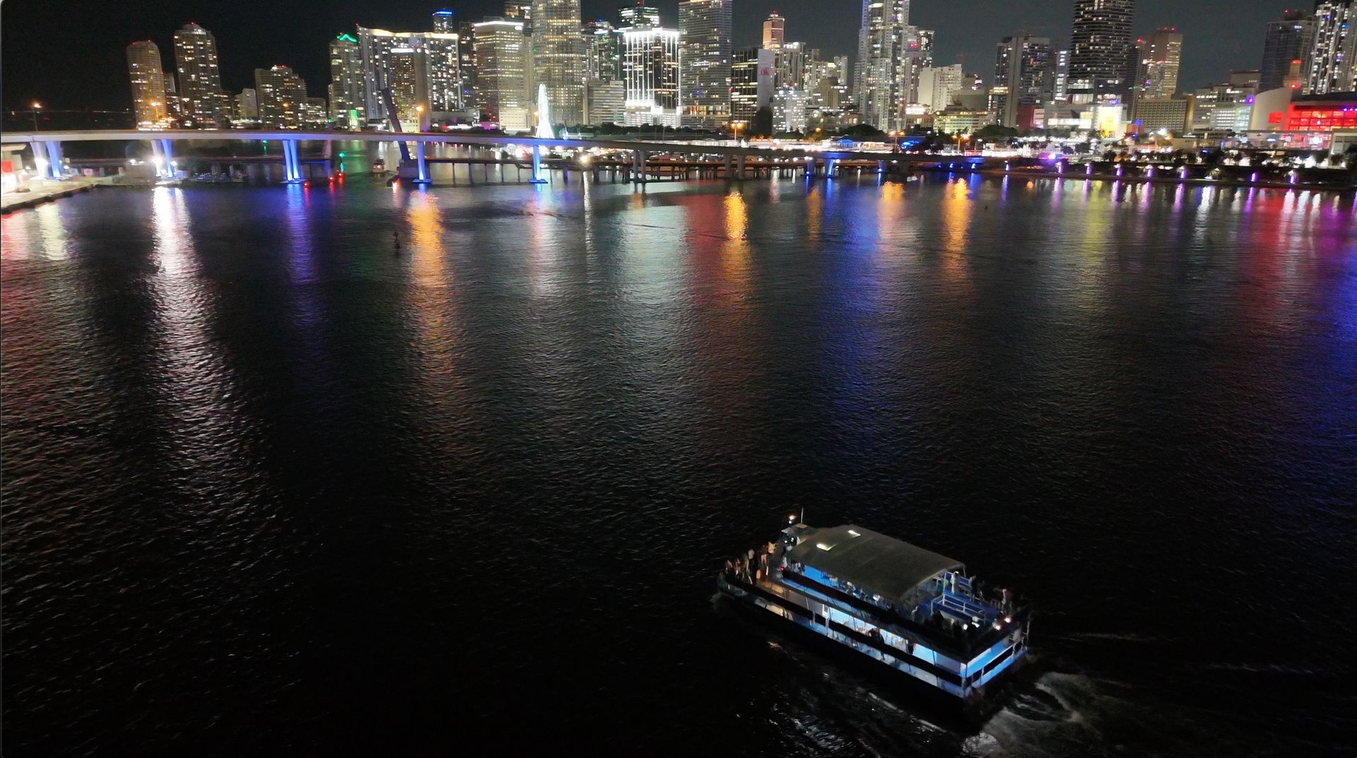 Miami skyline at night viewed from an open-air top deck during a Miami night cruise.