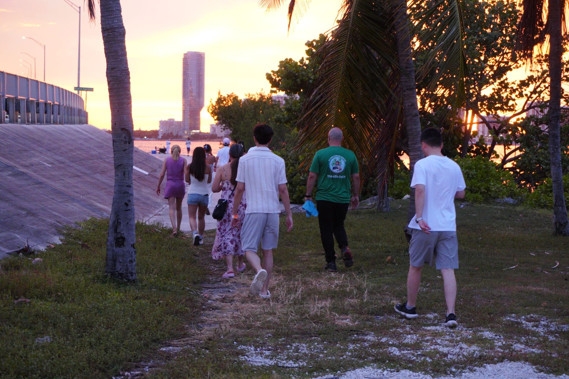 Visitors enjoying a sunset view along the waterfront in a Miami park