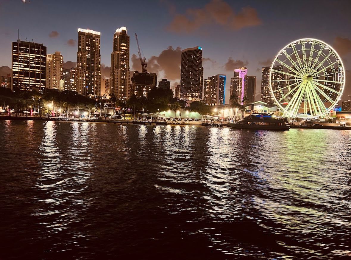 Miami skyline at night viewed from the water with city lights and the Bayside Ferris wheel