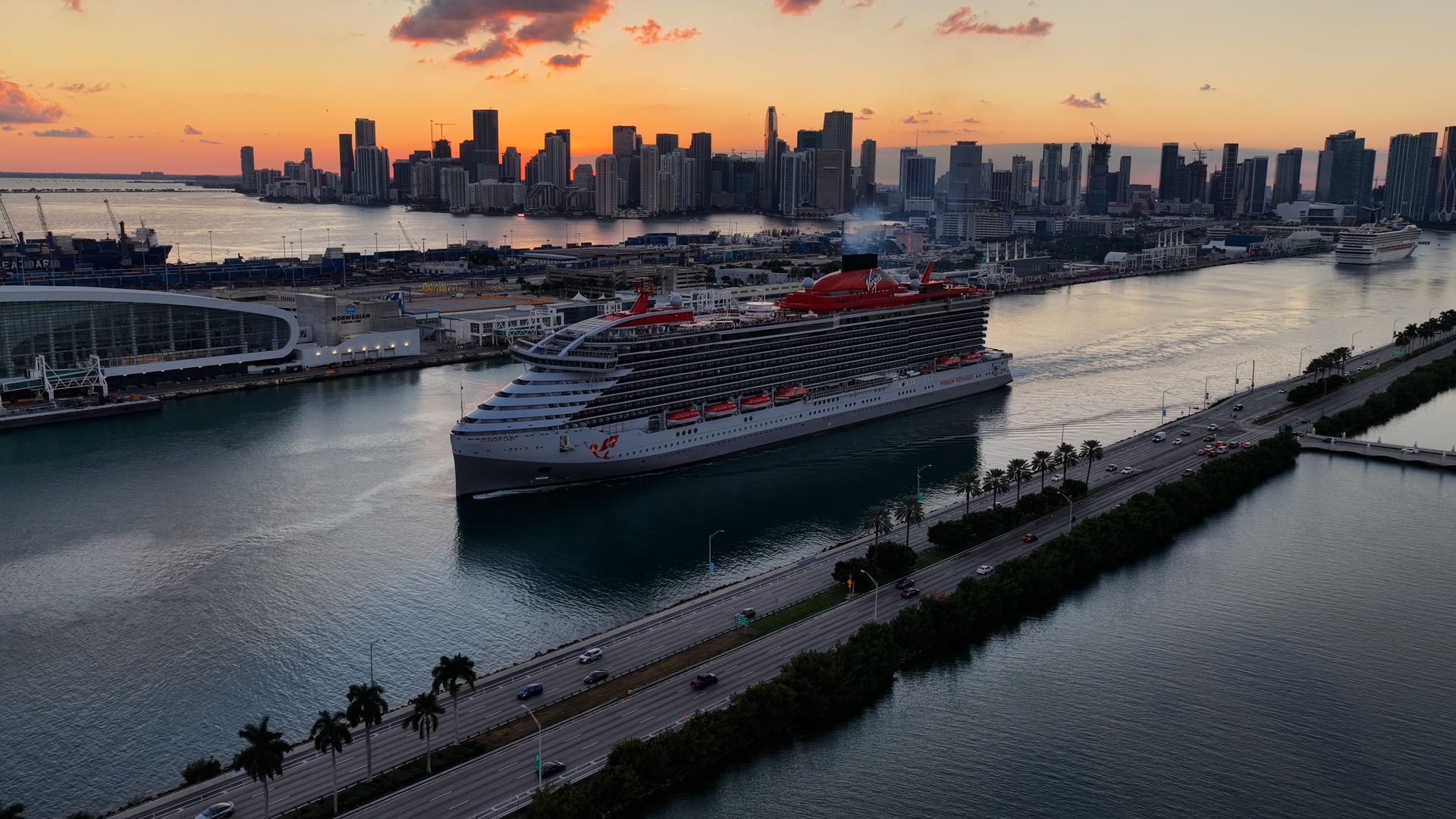 Miami skyline at sunset viewed from the water with downtown buildings and cruise ship.