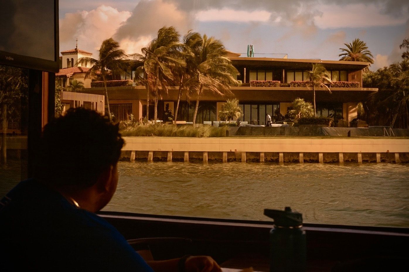 Guest enjoying celebrity mansion views during a Miami sunset cruise on Biscayne Bay.