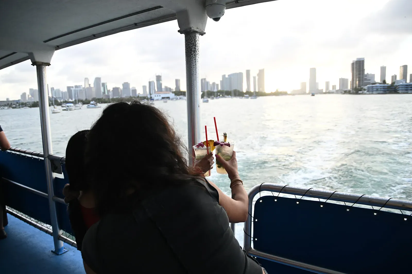 Guests enjoying cocktails during Miami Sunset Cruises with panoramic skyline views and sunset waterfront scenery
