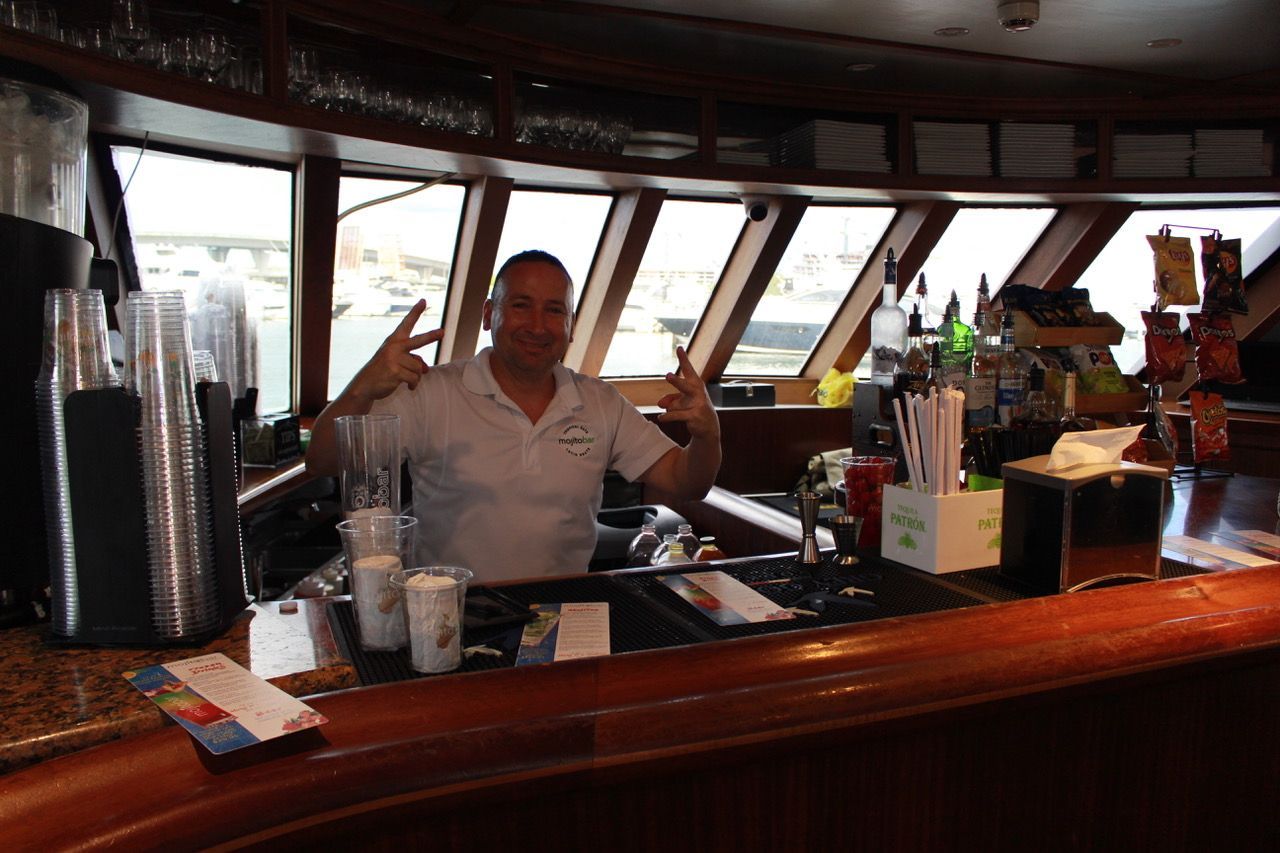 Bartender at Mojito Bar on the Miami Skyline Cruise Route Map serving drinks during the sightseeing boat tour from Bayside