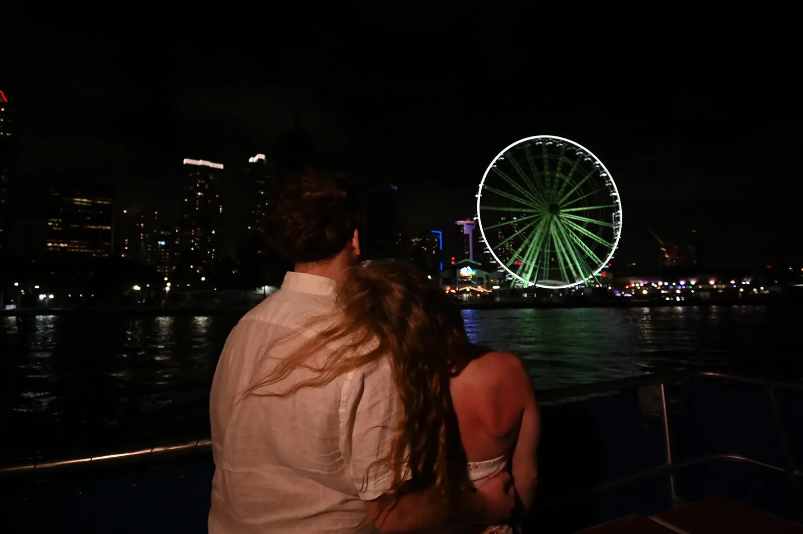 perfect night in Miami from the water with a couple enjoying the Miami skyline at night on Biscayne Bay
