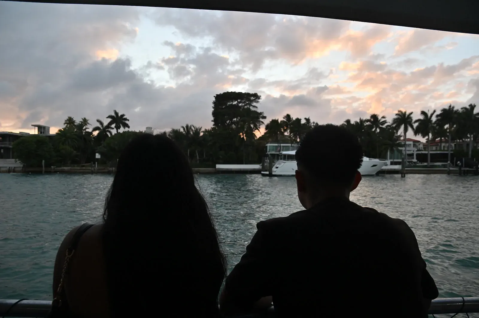 Couple enjoying a romantic sunset boat tour with waterfront views during a Miami evening cruise