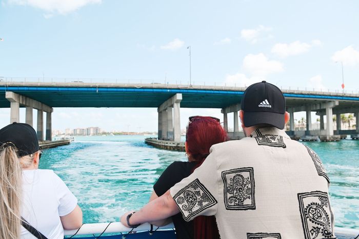Guests enjoying a Miami sightseeing boat tour while passing under the MacArthur Causeway bridge with views of Biscayne Bay