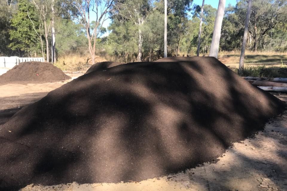 Large Pile of Dark, Rich Soil in A Wooded Outdoor Setting — Gladstone Garden & Landscaping Supplies In Burua, QLD