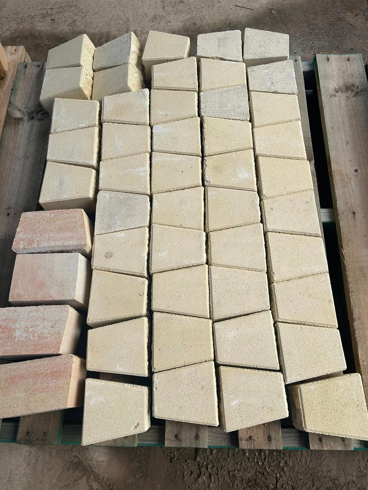 Pile of Beige, Trapezoid-Shaped Bricks on A Wooden Pallet, Likely for Construction — Gladstone Garden & Landscaping Supplies In Boyne Valley, QLD