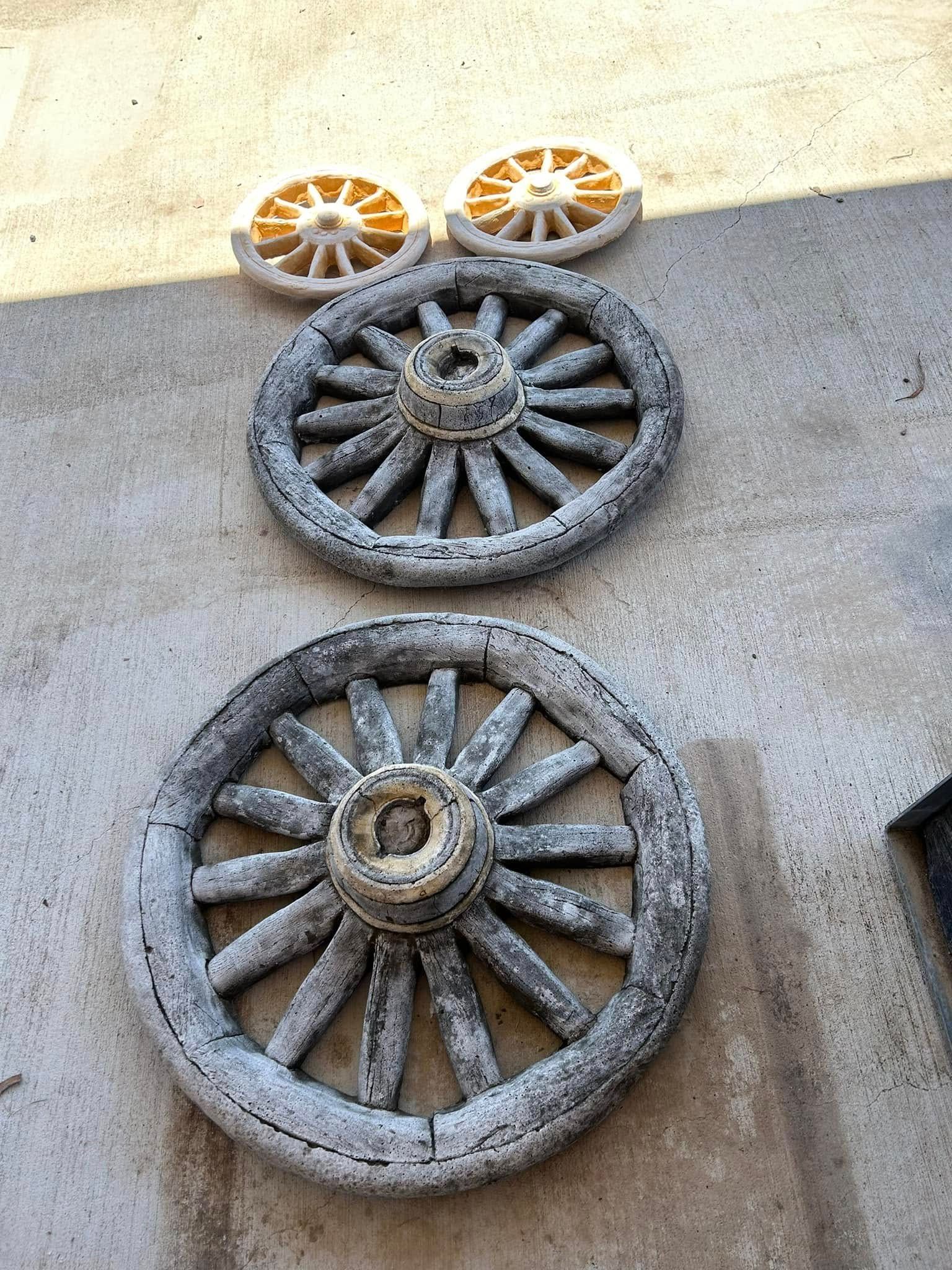 Four Weathered Wooden Wagon Wheels on A Concrete Surface — Gladstone Garden & Landscaping Supplies In Burua, QLD