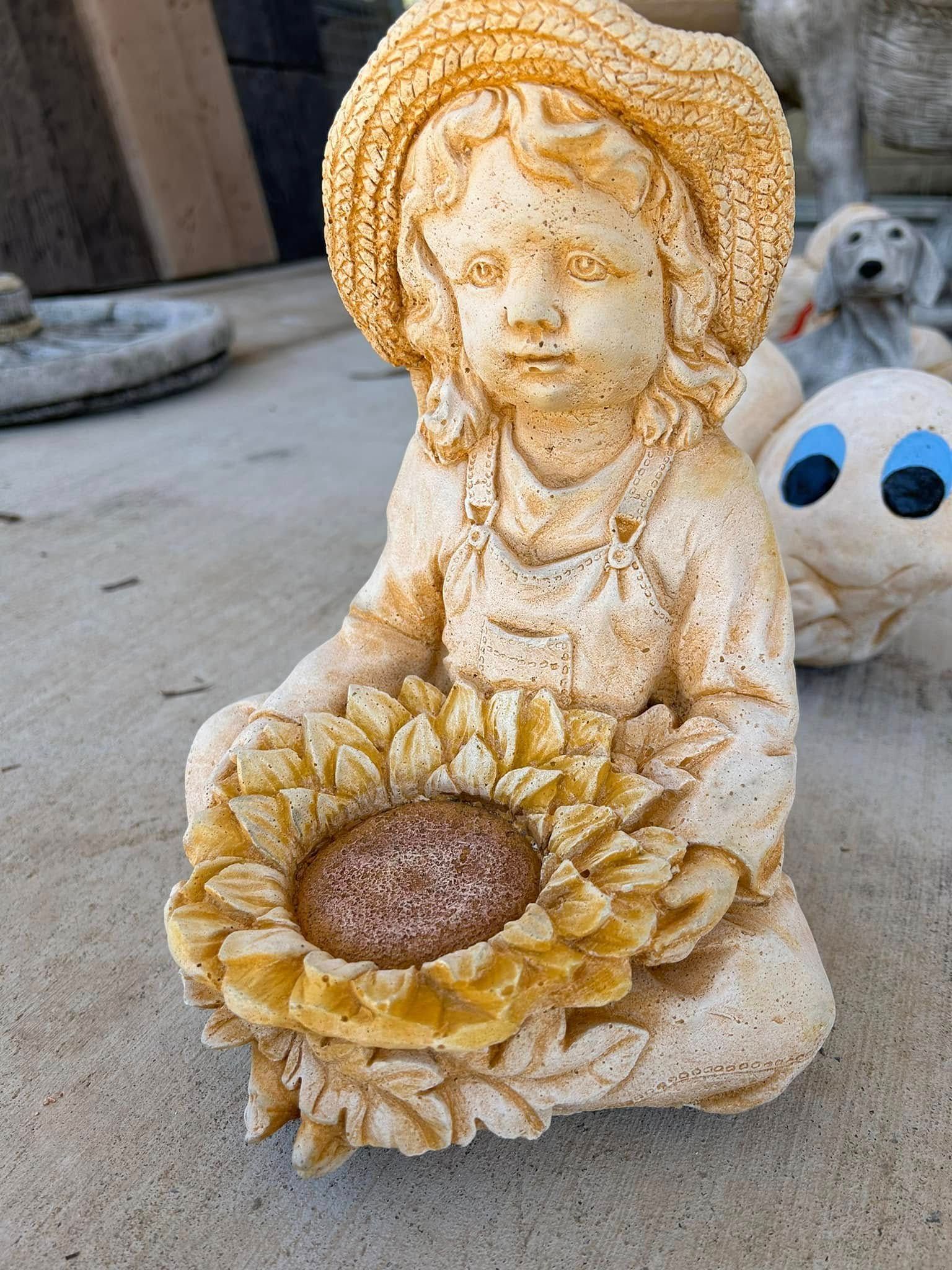 Statue of A Child with A Hat Holding a Sunflower, Cream and Yellow Colors — Gladstone Garden & Landscaping Supplies In Burua, QLD