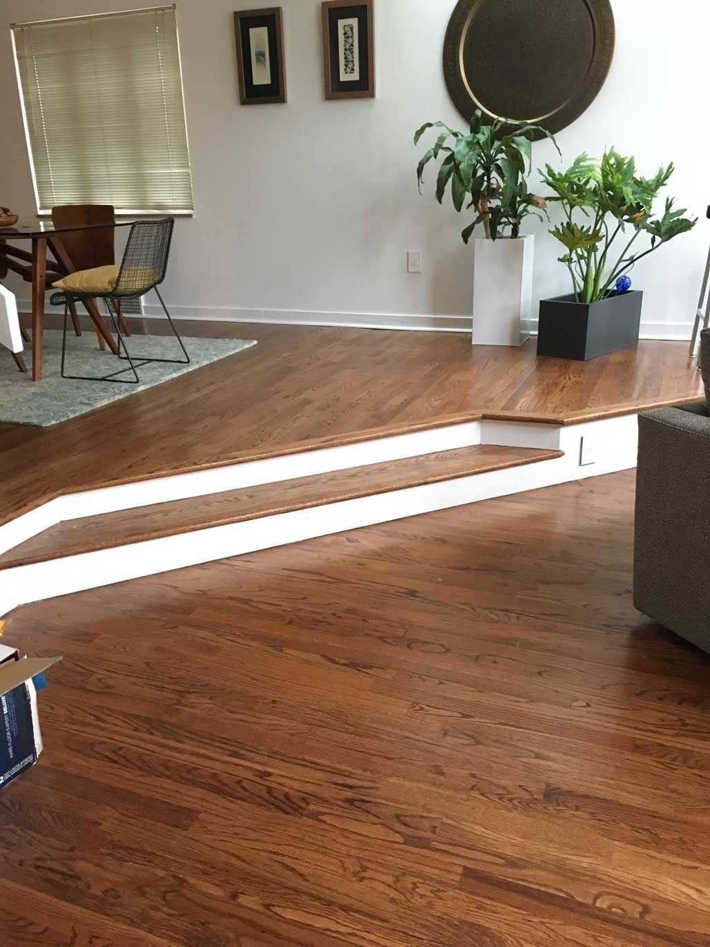 A living room with hardwood floors and white stairs