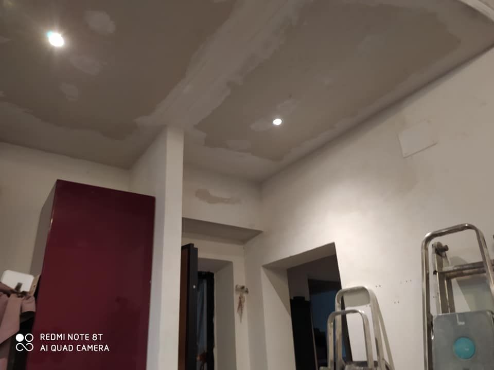 Una stanza con una scala e un soffitto in fase di ristrutturazione.