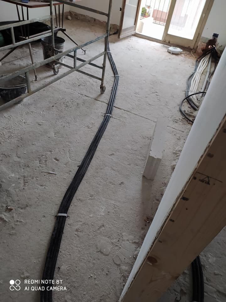 Un tubo è appoggiato sul pavimento in una stanza in costruzione.