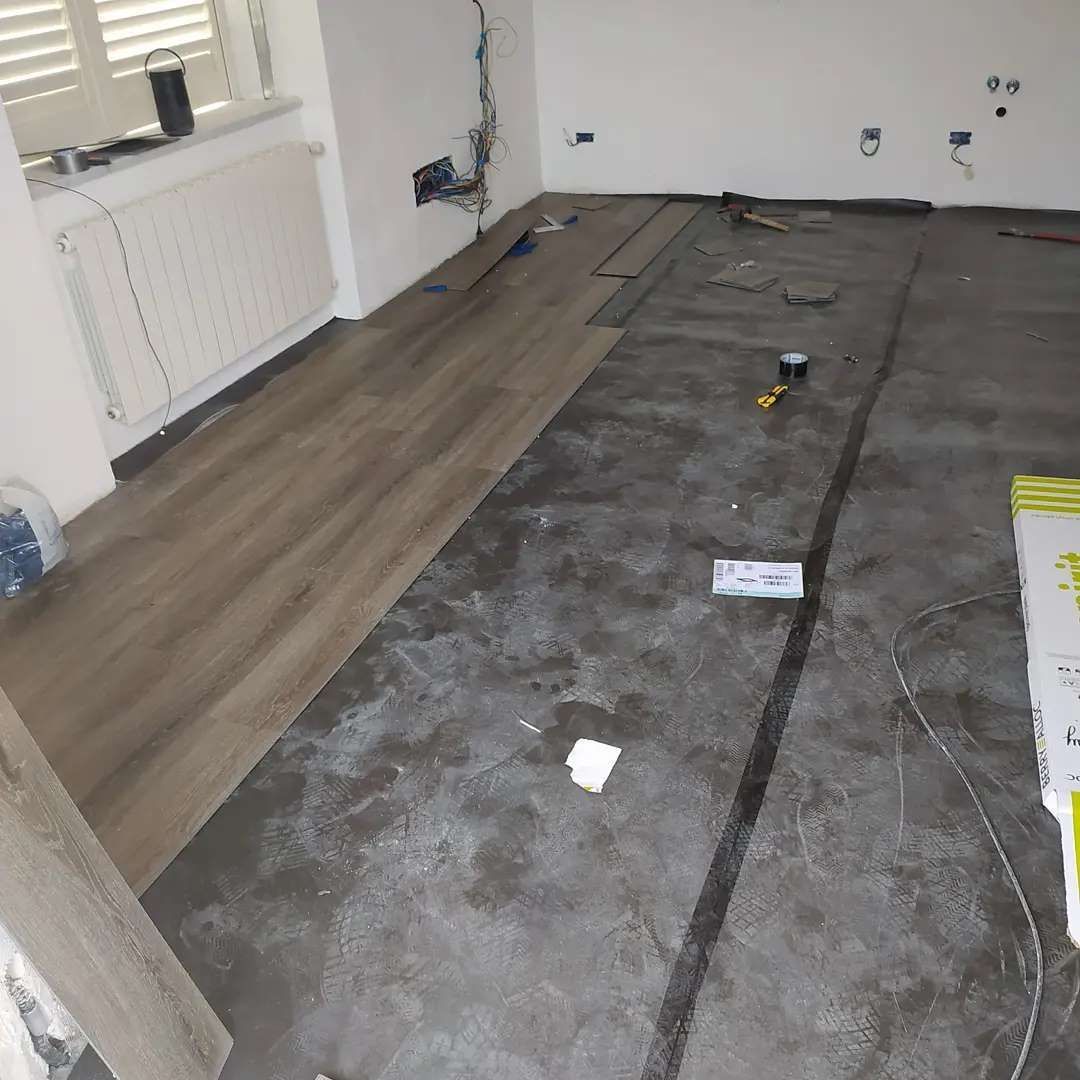 Una stanza con pavimento in legno e pavimento in cemento.