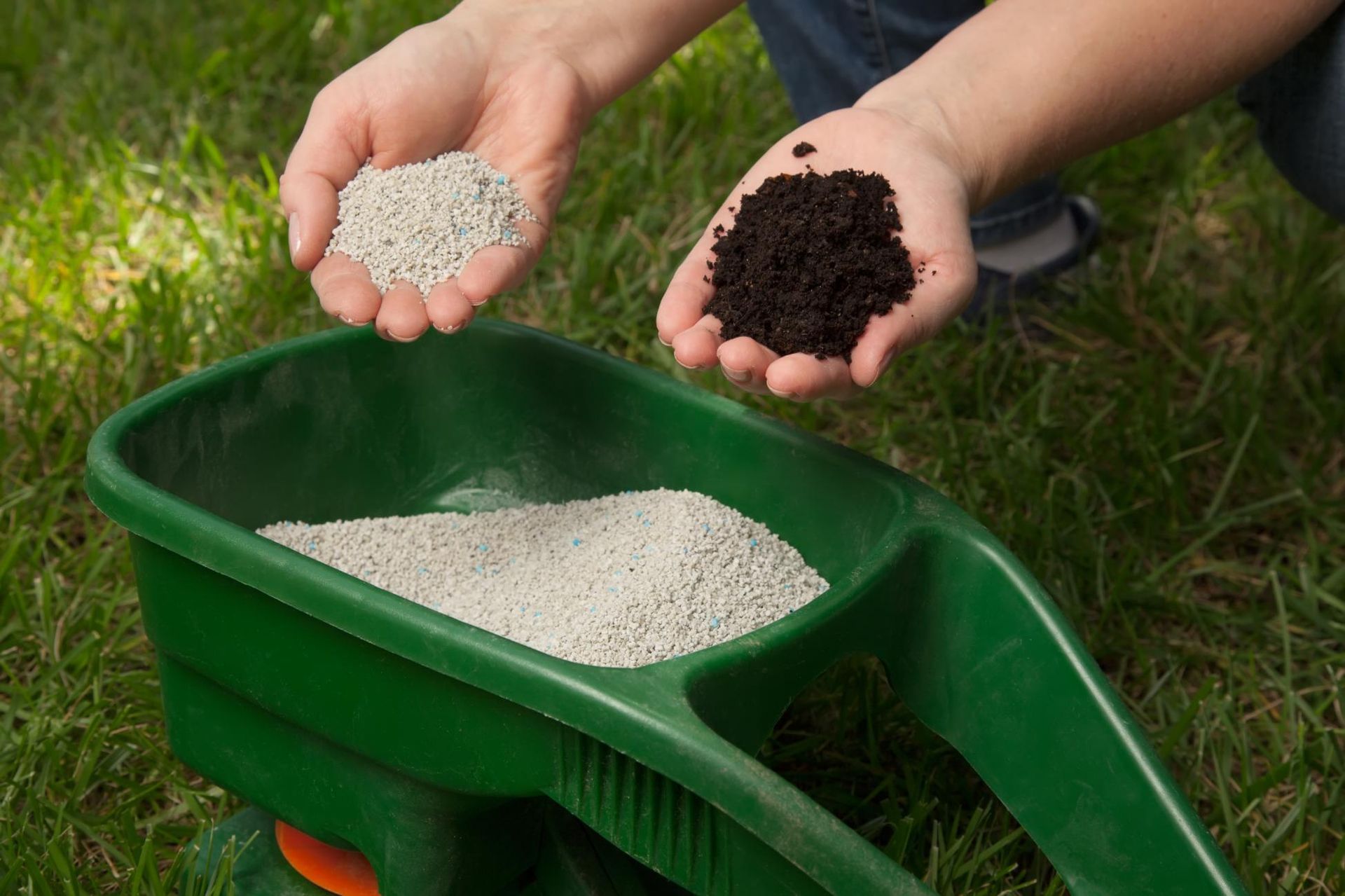 Hands hold white granules in one palm and dark soil.