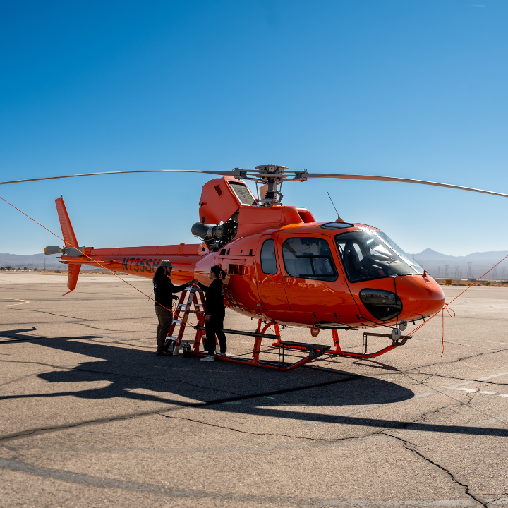 Technicians performing a Safran engine inspection on an Airbus AS350 helicopter on the ramp at Bould