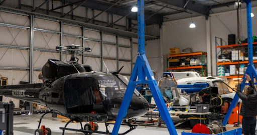 A helicopter is sitting on a lift in a hangar.
