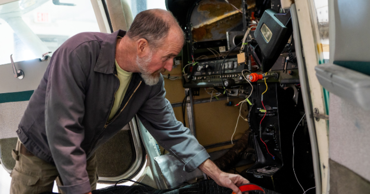 FAA-certified aircraft maintenance technician inspecting avionics inside an aircraft in Boulder City