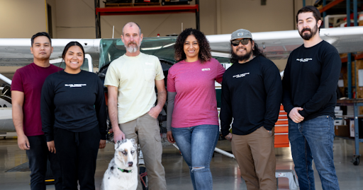 A group of Black Mountain Aviation technicians standing in front of an aircraft at the Boulder City