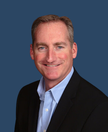 A man is holding a dog in his arms and the dog is wearing a sweater.