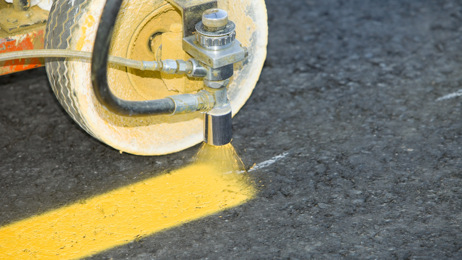 A machine is painting a yellow line on the road.