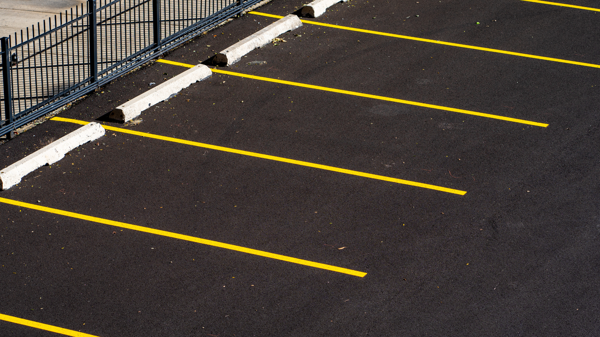 A parking lot with yellow lines and white curbs
