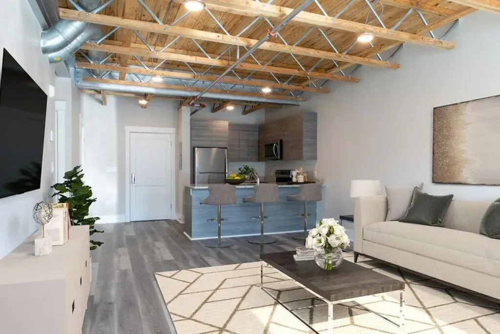 Modern living room with exposed ceiling beams and open kitchen.