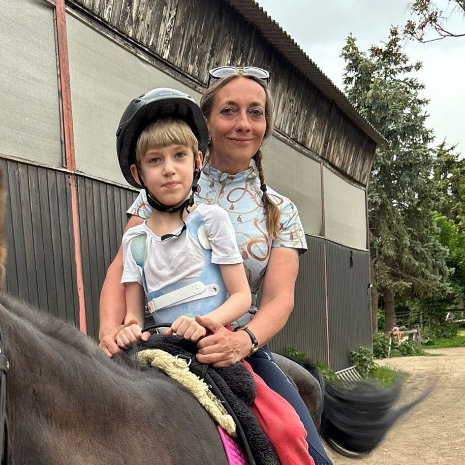 Ein Kind und eine Frau auf einem Pferd
