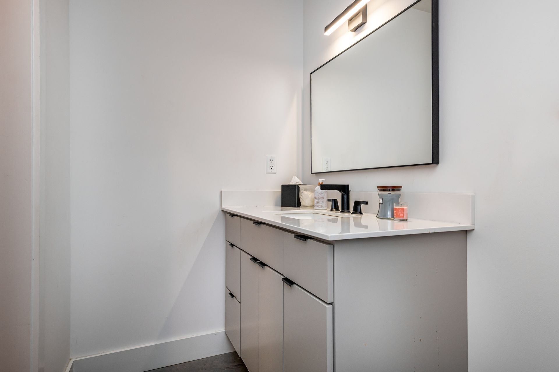 A bathroom with a sink , mirror and cabinets.