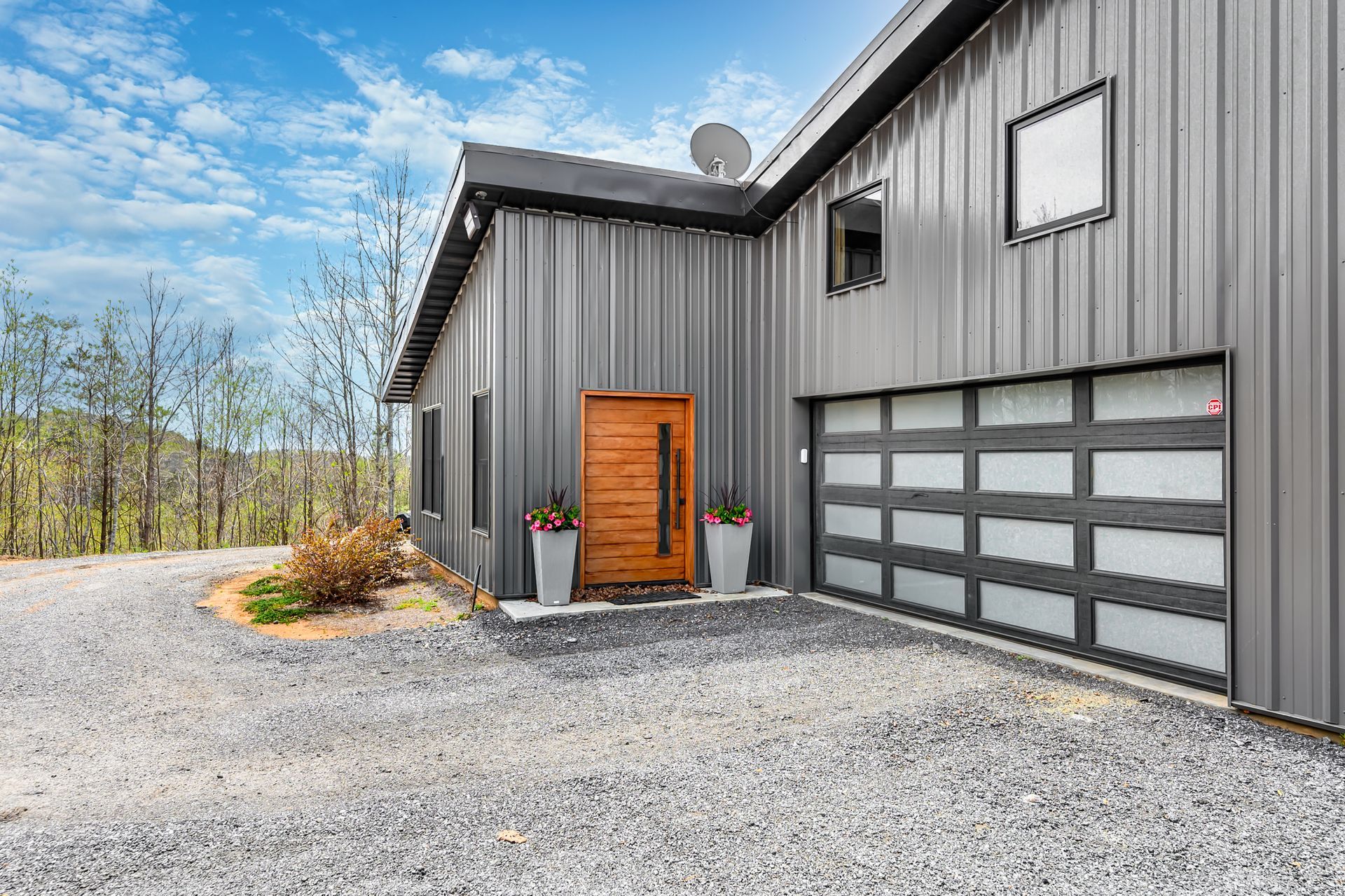 A large metal building with a garage door and a wooden door.