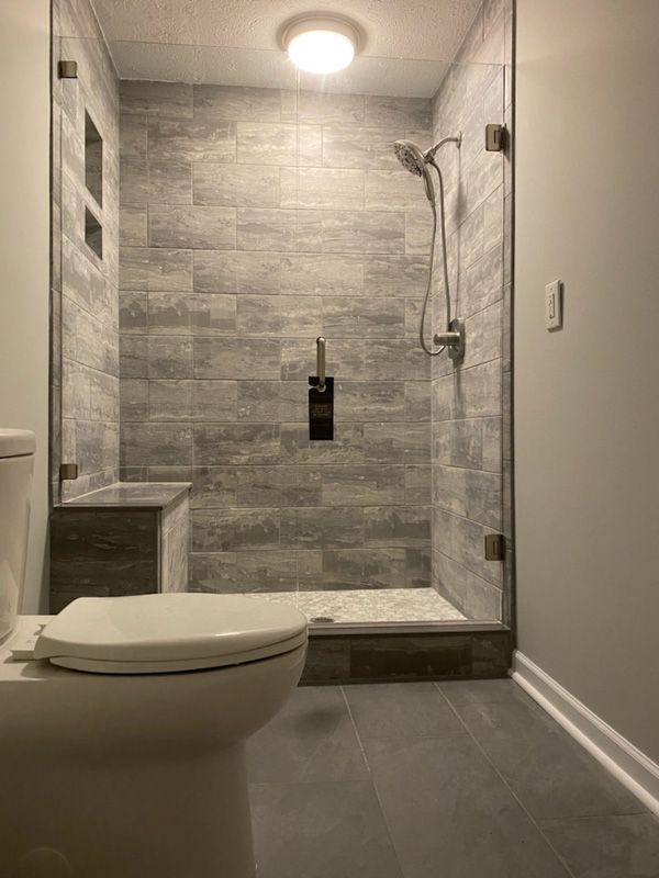 A bathroom with a toilet and a walk in shower.