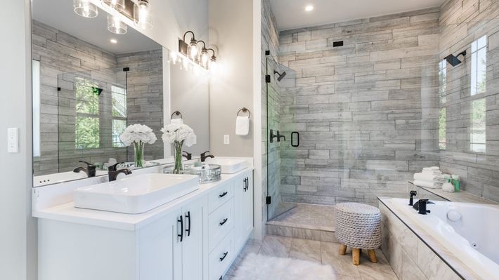 A bathroom with two sinks , a tub , and a walk in shower.