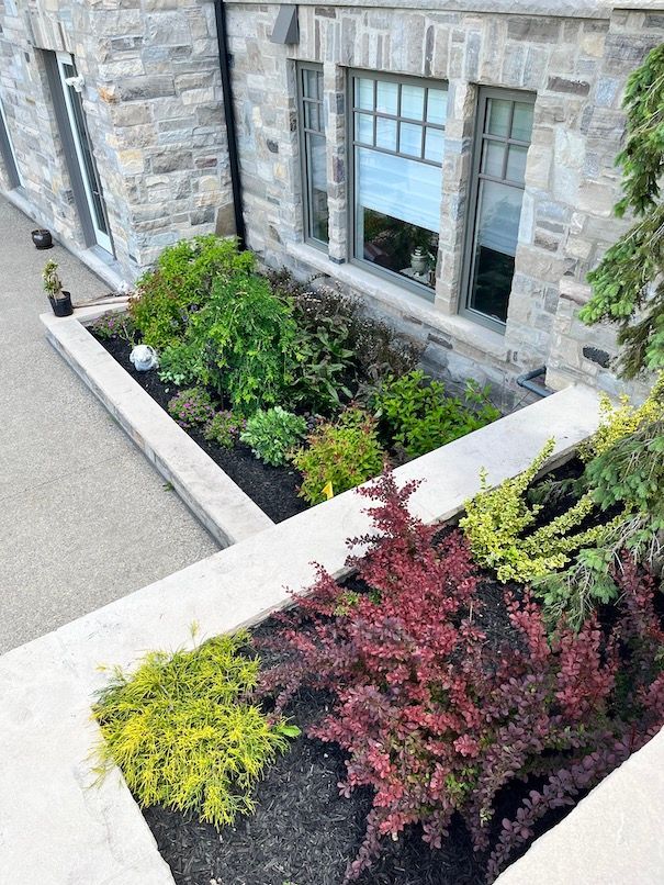 An aerial view of a garden in front of a stone building.