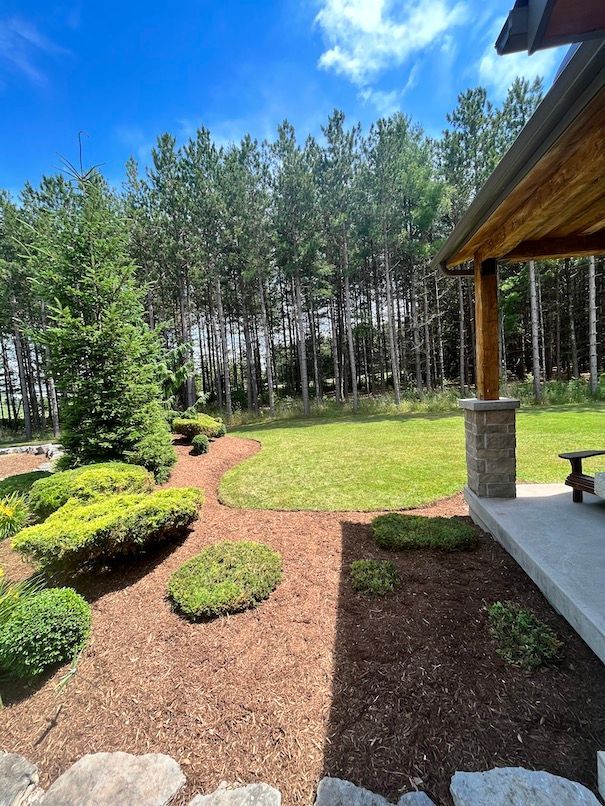 A house with a large lawn and trees in the background