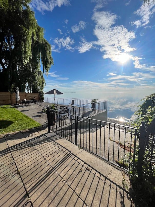 A patio with a fence and a view of the ocean