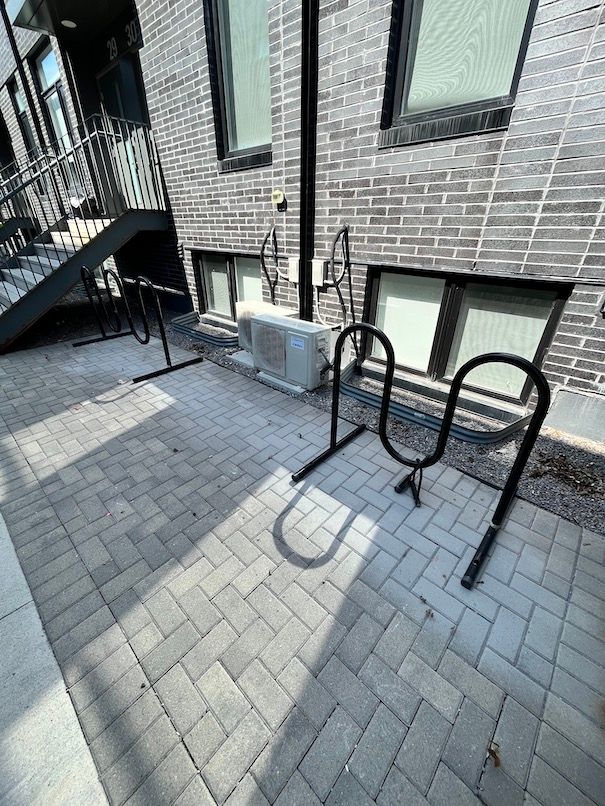 A brick building with a bicycle rack in front of it.