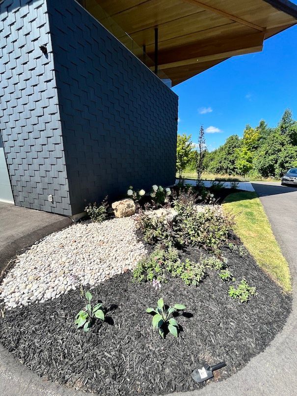 A car is parked in front of a building with a garden in front of it