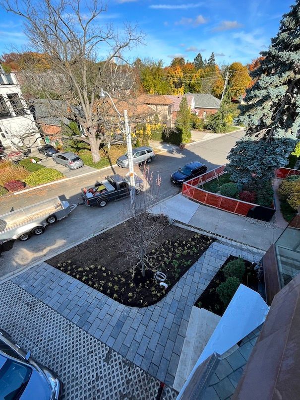 An aerial view of a residential street with cars parked on the side of the road.