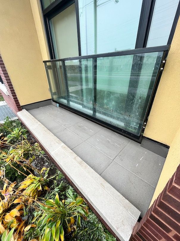 A balcony with a glass railing on the side of a building.